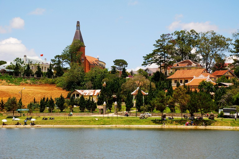 A bell tower and other buildings among the trees at a teaching collage in Da Lat city, Vietnam