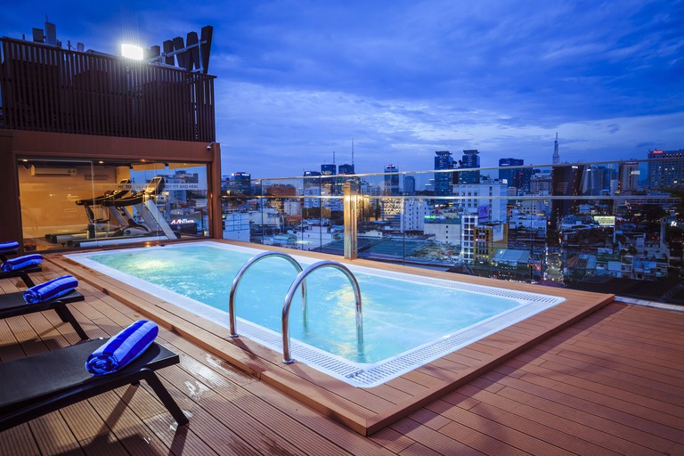 Rooftop gym and outdoor pool at Winsuites Saigon in Ho Chi Minh City, offering impressive views of the city.