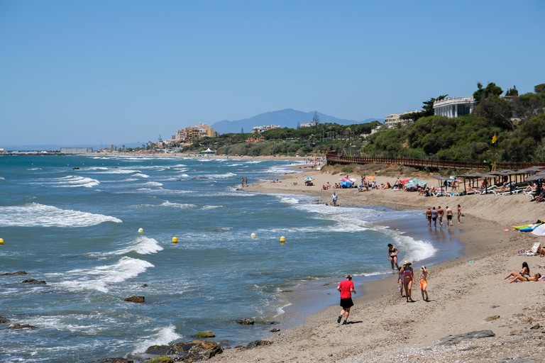 People relaxing and walking along the beach at Calahonda, Costa del Sol