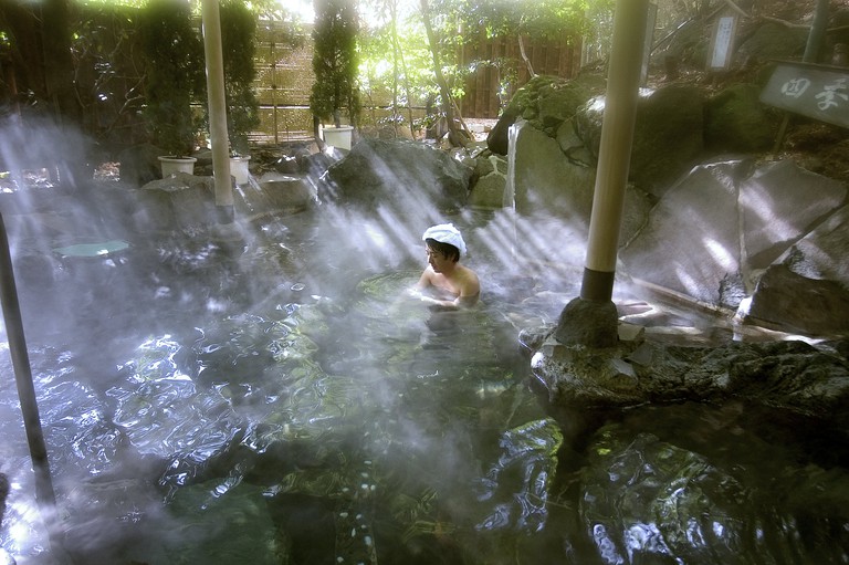 Person bathing in a hot spring called an Onsen in Hakone, Japan