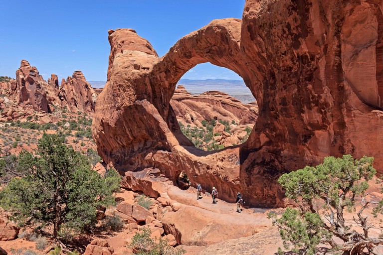 United States Utah Colorado Plateau Arches National Park Devil's Garden section hikers at Double O Arch