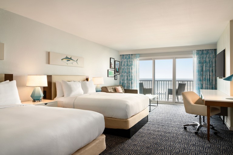A room at DoubleTree by Hilton Ocean City Oceanfront, with two double beds, a desk and a balcony