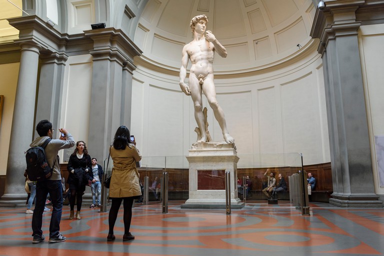 Florence. Italy. Tourists visit Michelangelo's statue of David at the Galleria dell'Accademia museum. Gallery of the Academy of Florence.