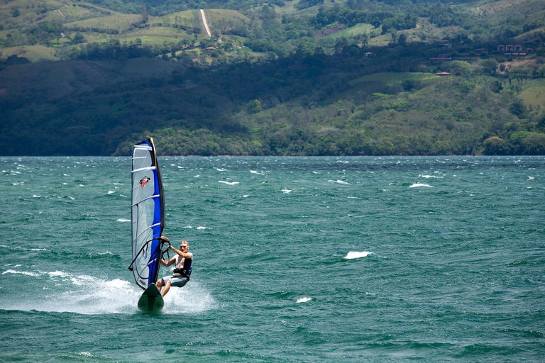 BE1MAM A wind surfer sails across Lake Arenal In Costa Rica