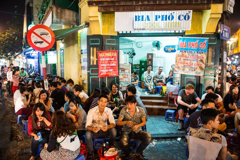 DPAY8R Tourist and locals enjoying draft beer on the Bia Hoi Corner in Hanoi, Vietnam