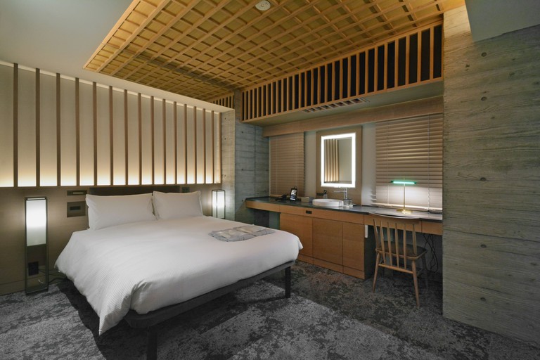Modern double room in Hotel Hillarys Akasaka with simple white bed and wooden wall and ceiling