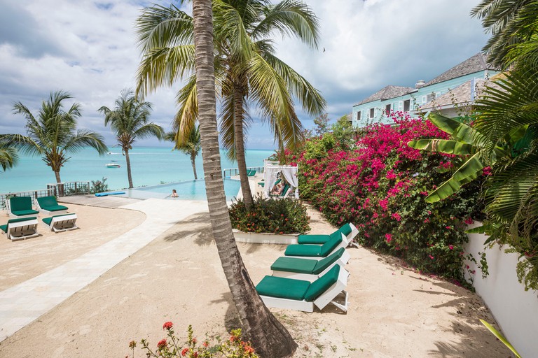 Sunbeds and palm trees overlook the Caribbean at Sheer Rocks on Ffryes Beach