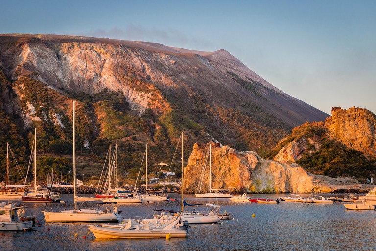 The marina of Vulcano at sunrise with the volcano slopes, Aeolian Islands, Sicily.
