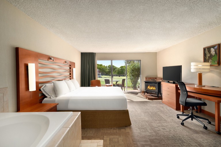 Spacious double room with a fireplace, desk, bathtub and outdoor terrace at Poco Diablo Resort, Sedona.