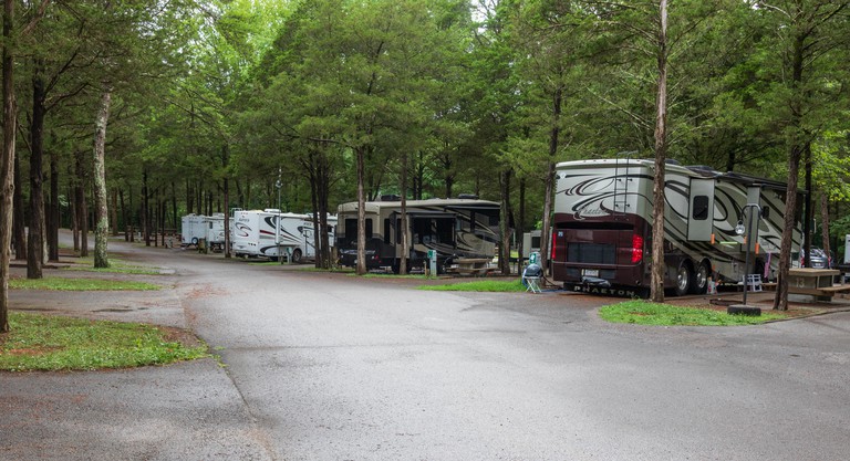 A line of class A RVs, in Cedars of Lebanon State Park campground, on a rainy day.