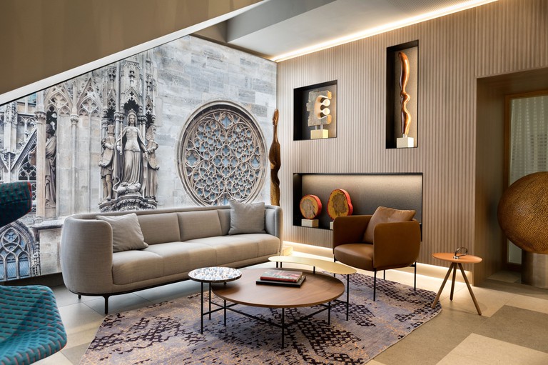 Designer seating and sculptures in a stylish sitting area at Boutique Hotel am Stephansplatz, with photo mural of cathedral on wall