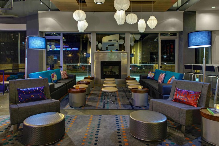 Cosy communal space in Aloft Durham Downtown with grey, blue and orange colour scheme