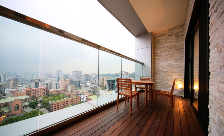 A wooden terrace at Solaria Nishitetsu Hotel Seoul with views over the city