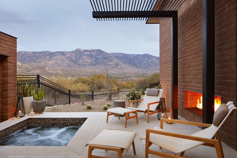 Small in the ground jacuzzi at Miraval Arizona Resort & Spa with views over mountains and fire place