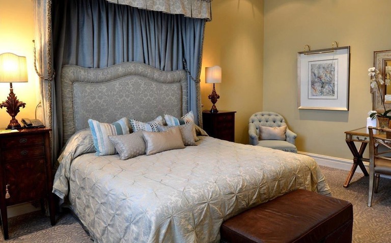 A cosy guest room at the Monarch Hotel with a double bed and antique furniture