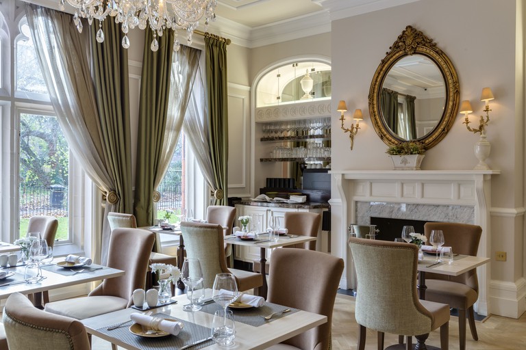St Pauls Hotel dining area in grand style with chandelier, ornate mirror and garden views