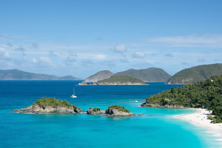 Islands dot the sea at Trunk Bay with sun bathers relaxing on a white-sand beach, St John, US Virgin Islands