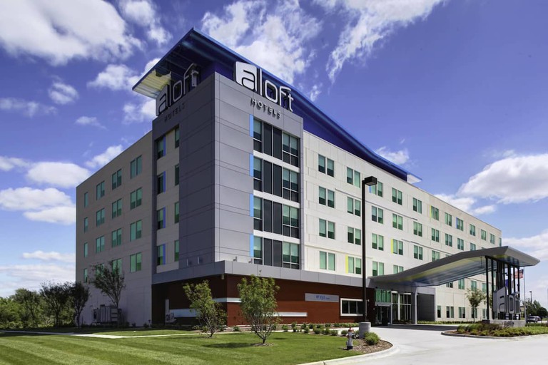 The five-story Aloft Wichita surrounded by landscaping