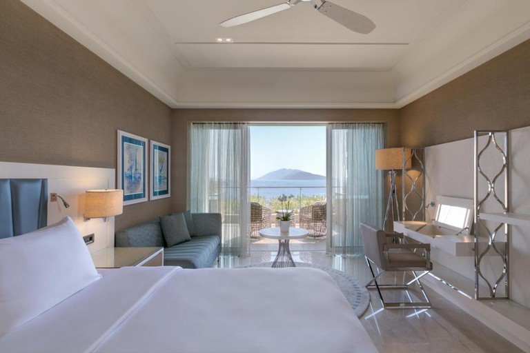 Blue, white and cream double bedroom with views overlooking the Aegean Sea at Caresse, a Luxury Collection Resort & Spa