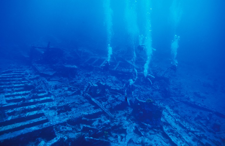 DIVERS EXPLORE THE SHALLOW STERN SECTION OF THE RHONE SHIPWRECK OFF SALT ISLAND BVI