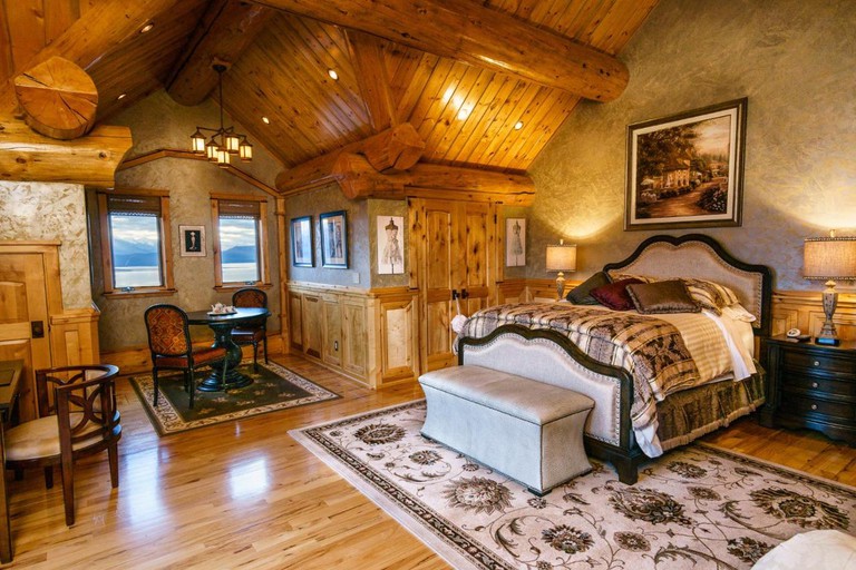 A rustic-chic guest room at Coyote Bluff Estate with traditional decor and wooden construction