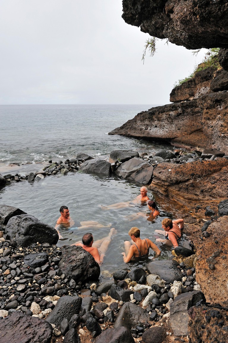 A group of travellers relax in hot springs at Bouillante, Basse-Terre, Guadeloupe
