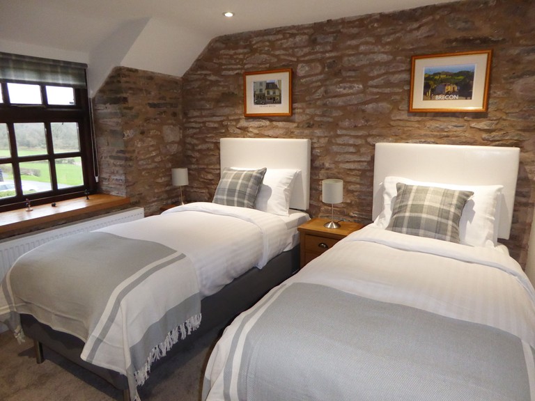 Hilltops Brecon twin room with bare brick walls and minimal decor