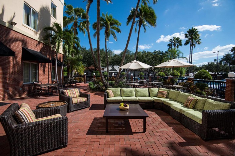 Large outdoor seating area with L-shaped sofa and armchairs at Hilton Garden Inn Tampa Ybor Historic District
