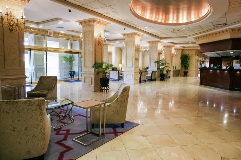 Sleek cream-colored lobby with rectangular columns and chandeliers at the Hilton Jackson