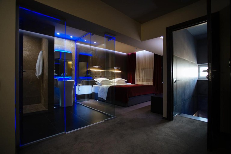Room at the LH Hotel and SPA with double bed, glass walls and blue lights