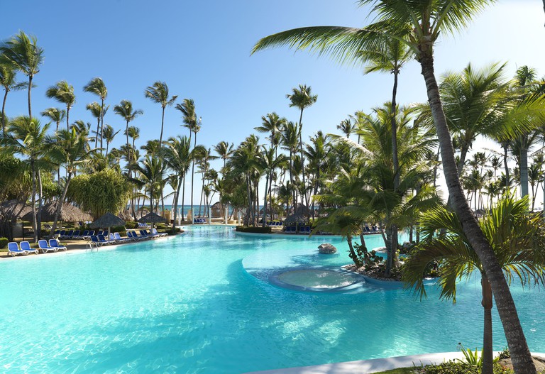 Immense pool area with palms and palapas at Meliá Caribe Beach Resort