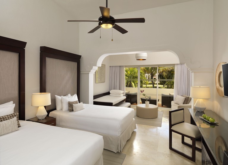 Clean white linen on two beds and sitting area in Melia Caribe Beach Resort