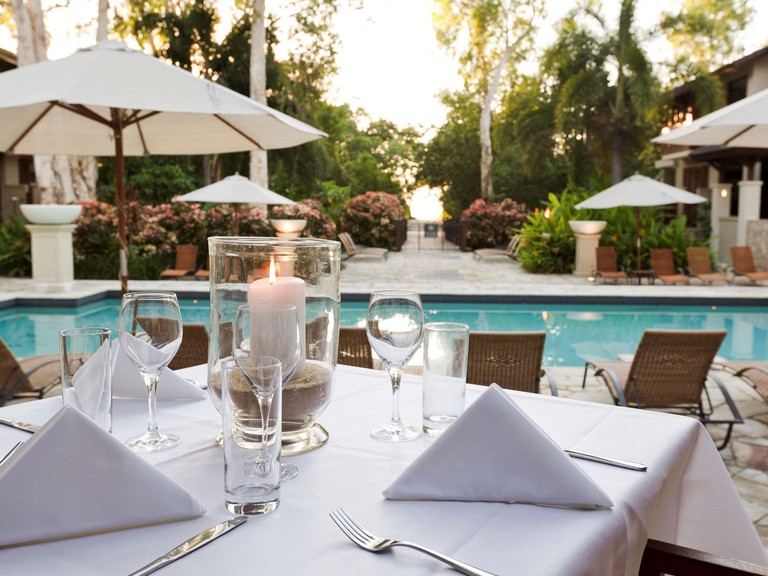 Romantic dining table at Pullman Palm Cove Sea Temple Resort, with pool views
