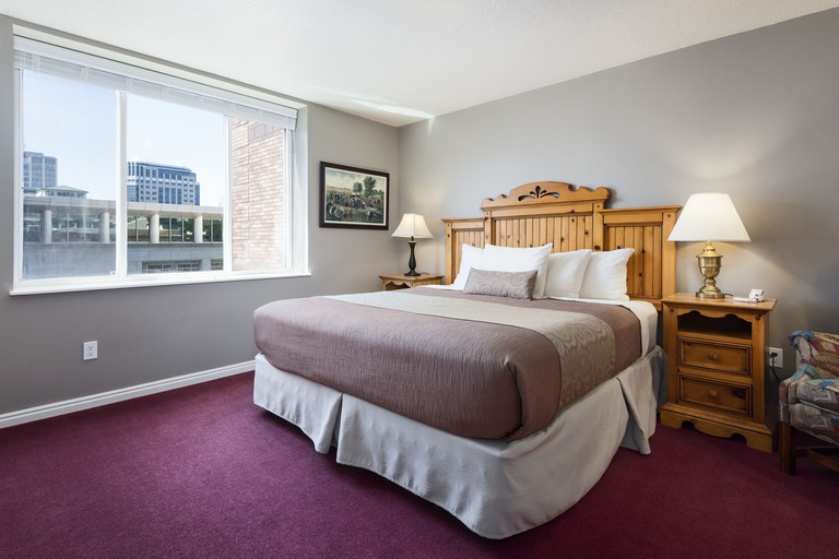 Double room at The Kimball, Temple Square with view over the city, decorated with purple carpet and wooden headboard