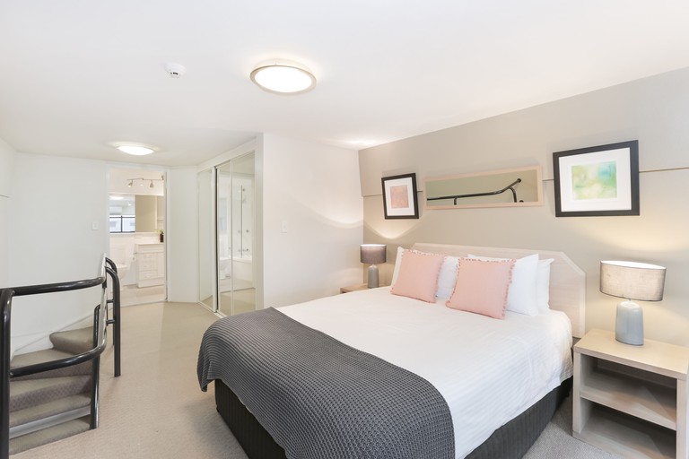 Loft bedroom in soft, light colors and en-suite bathroom