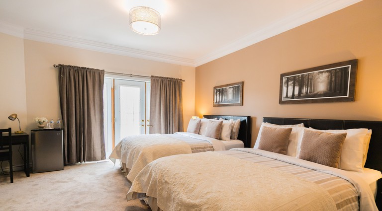 Large room with two king beds, wall art and beige carpeting