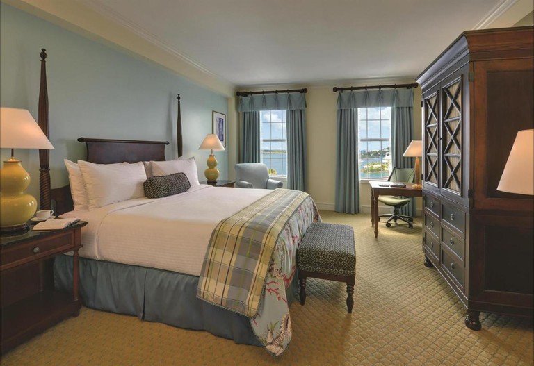 A traditional bedroom at the Hamilton Princess & Beach Club with a dark-wood cupboard