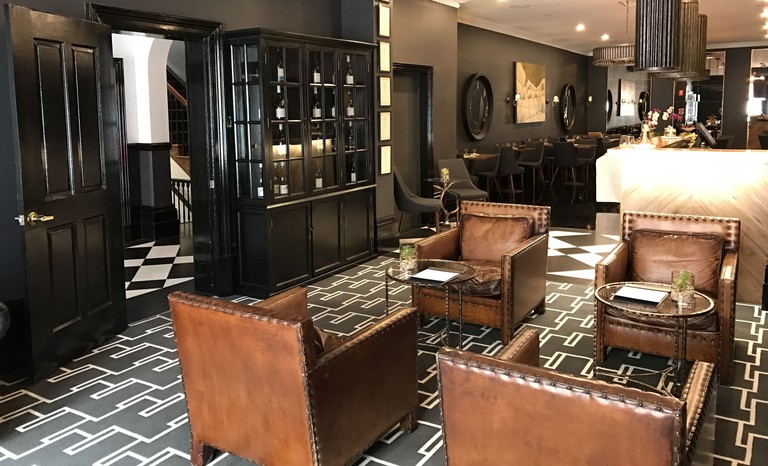 Bar and restaurant with leather armchairs and modern wall art at the Macquarie Manor Hotel
