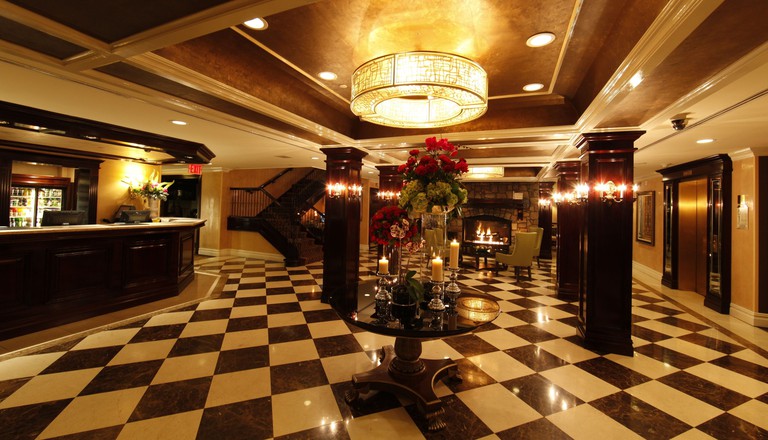 The upscale lobby area with polished checkered floors and a fireplace at the Inn at Fox Hollow