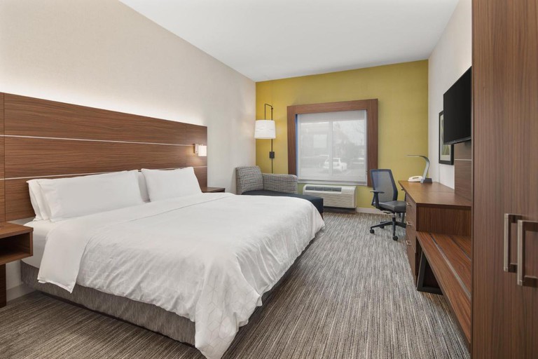 A large bed in a Holiday Inn Express Hotel & Suites Sacramento Airport Natomas room (not in Woodland)