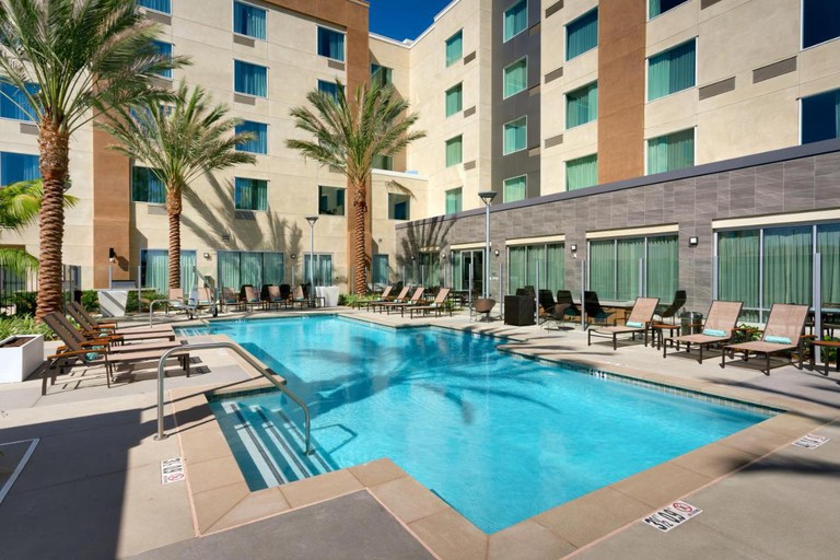 The spacious outdoor pool area with loungers and palms at the Courtyard by Marriott Los Angeles LAX/Hawthorne