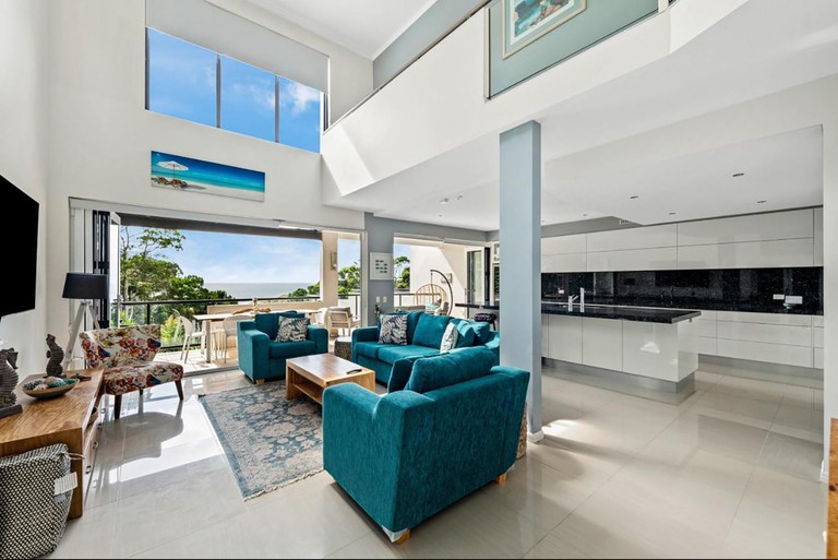 Interior of a villa at Papillon Coolum, which has high ceilings, a large window front, modern decor and a clean, luxurious look