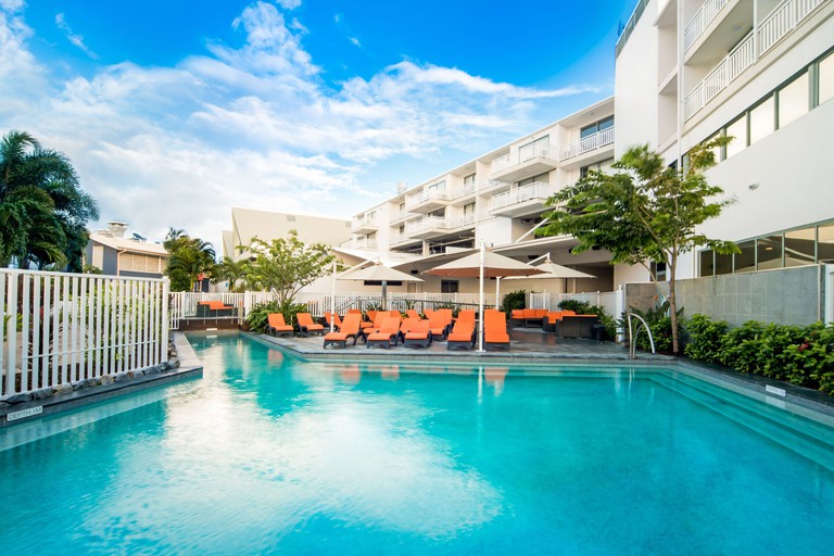 The large pool and orange loungers of Airlie Beach Hotel