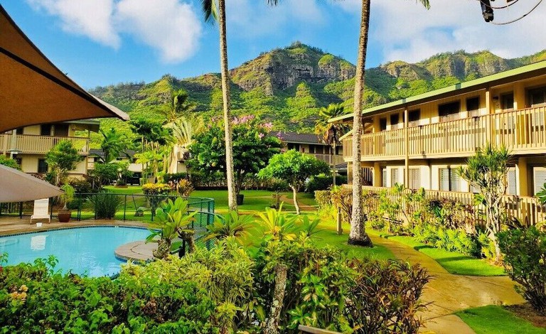 The lush grounds of Kauai Inn in Lihue with green mountains rising behind it