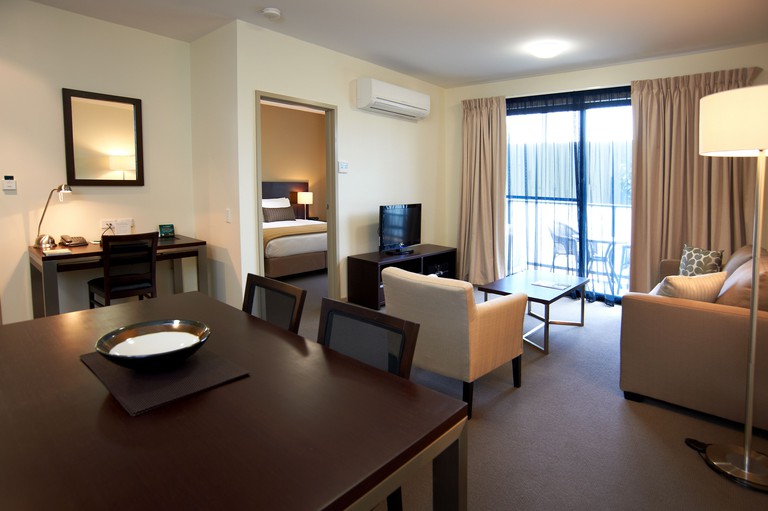 A large suite at Quest Moorabbin in Hampton, Victoria, Australia with dark wood furnishings