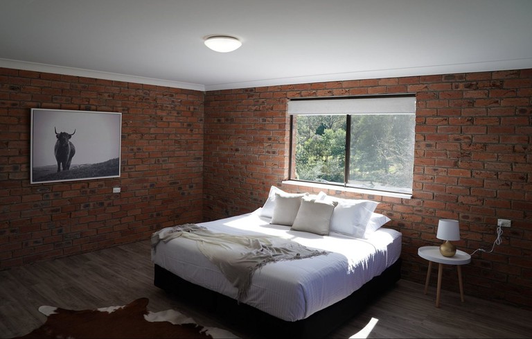 Chic room at McCarthy Grove with bare brick walls, photography and hide rug
