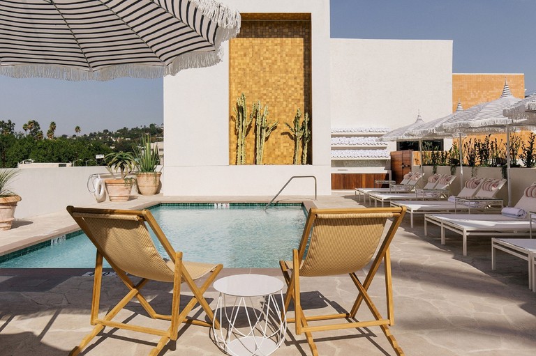 The laid-back hipster pool area with lounge chairs and umbrellas at Silver Lake Pool and Inn