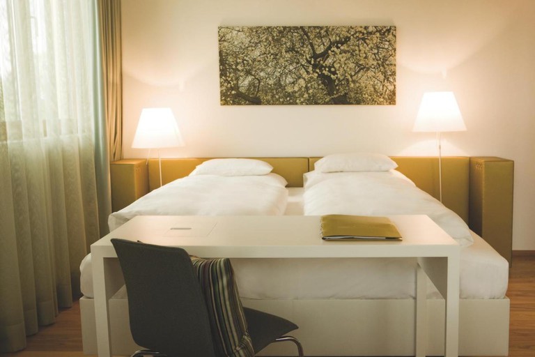 Simple room with wall art and desk at Hotel am See