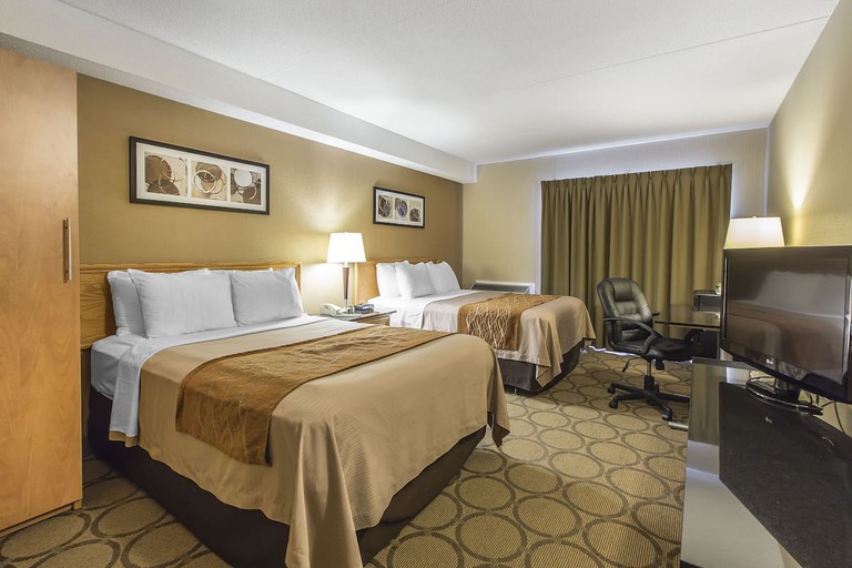 A guest room decorated with tones of brown and two queen-size beds at the Comfort Inn Magnetic Hill