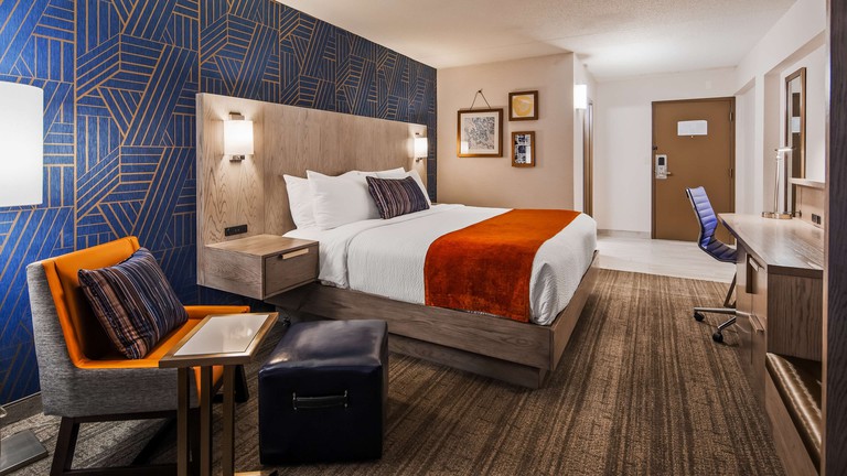 Modern king room with patterned royal blue wall and orange and red accents at Best Western Plus Landmark Inn in Lincoln City
